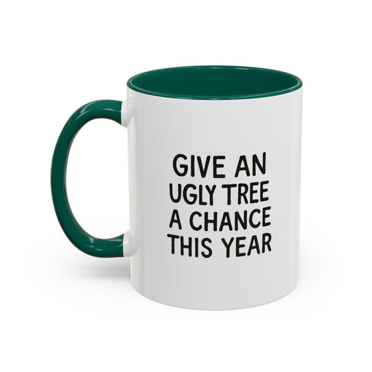 Mug with a pathetic looking Christmas tree design on a white background, with contrasting green interior handle and interior. With text 'Give an ugly tree a chance this year'
