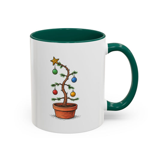 Mug with a pathetic looking Christmas tree design on a white background, with contrasting green interior handle and interior. With text 'Give an ugly tree a chance this year'